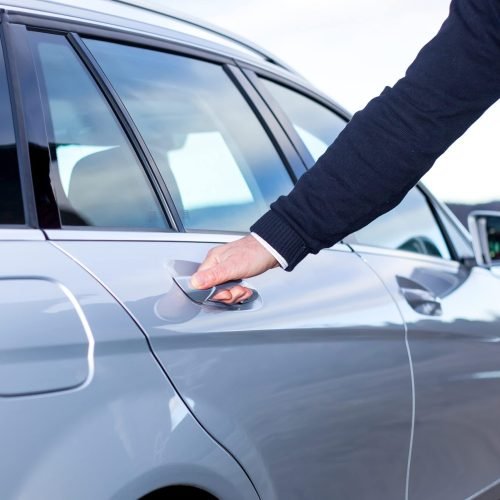 man holding car door handle